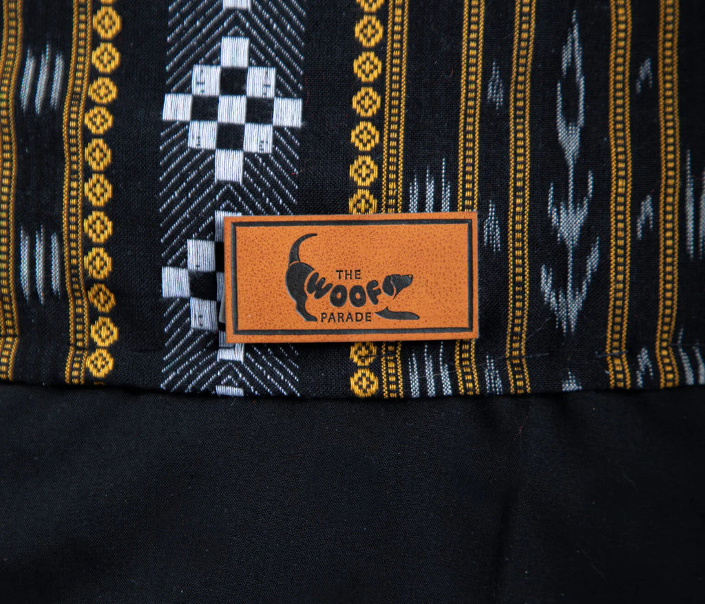 Close-up of the high-quality fabric and woven traditional motifs of the Assamese dog kurta, featuring "The Woof Parade" signature leather patch.