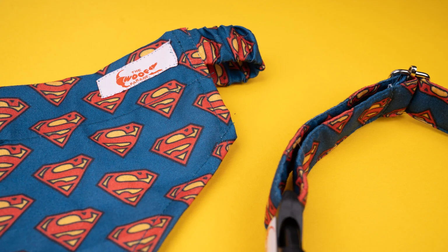Close-up of the vibrant Superman superhero print on a matching dog bandana and collar set by The Woof Parade.