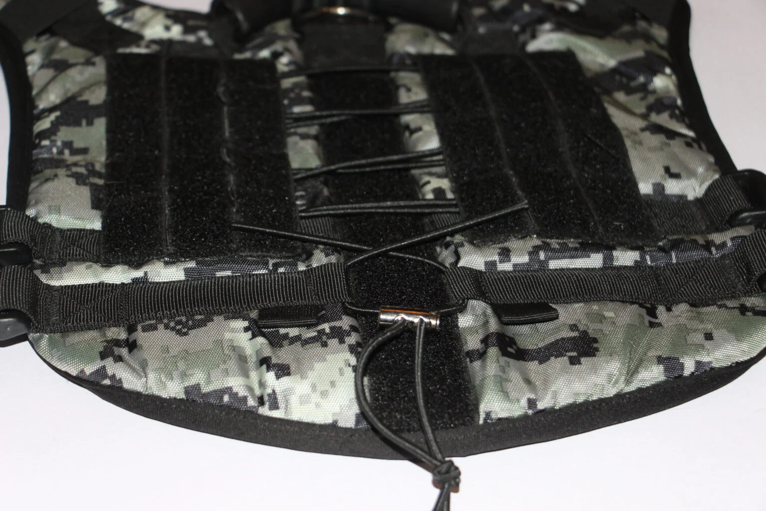 Close-up of the grey camo tactical harness showing the Molle-style straps and reinforced D-ring for secure attachment by The Woof Parade.